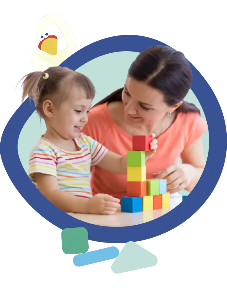 A teacher and a young child building a tower of coloured blocks together